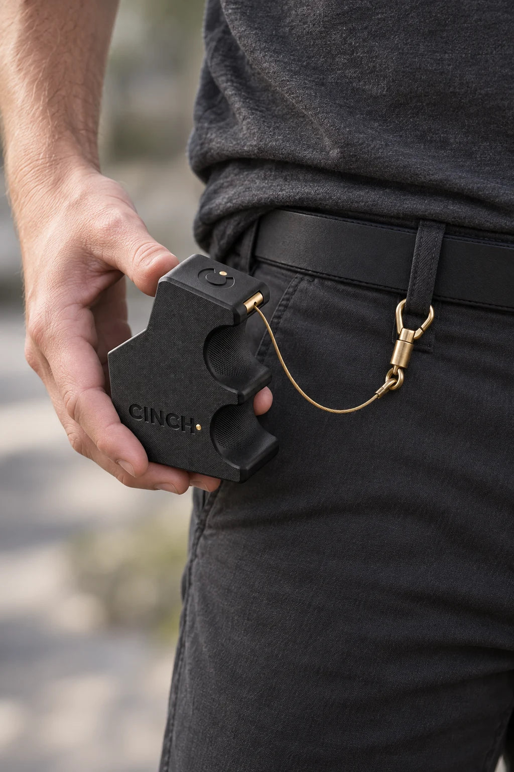 The loader held at the hip, its brass swivel clip secured to a belt loop (concept render)